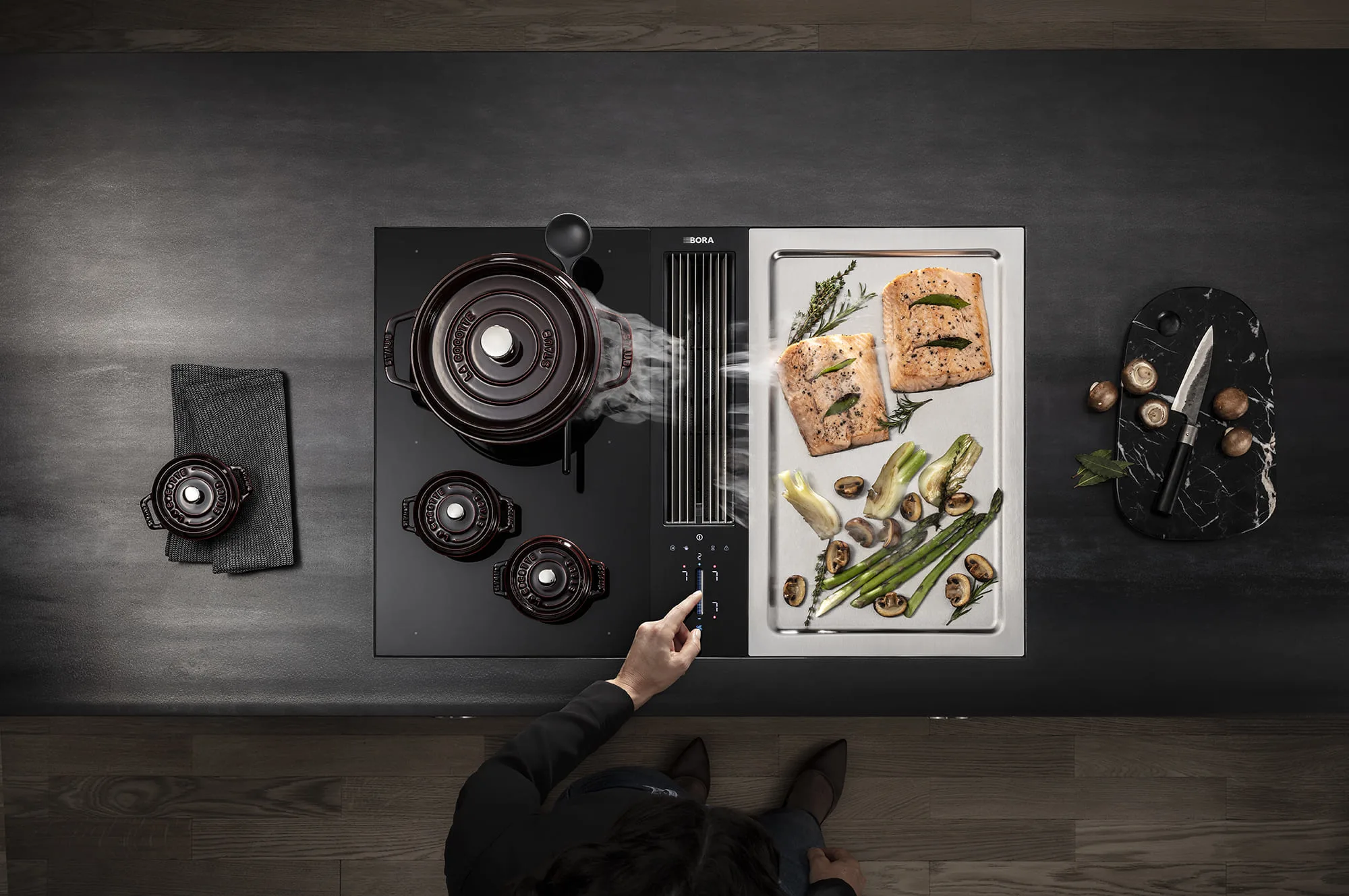 heaizobogztwtt84mat1 BORA Classic 2.0 kuhinjski sistem, pogled odozgo – kuvanje i pečenje lososa i povrća na Tepan ploči od nerđajućeg čelika.