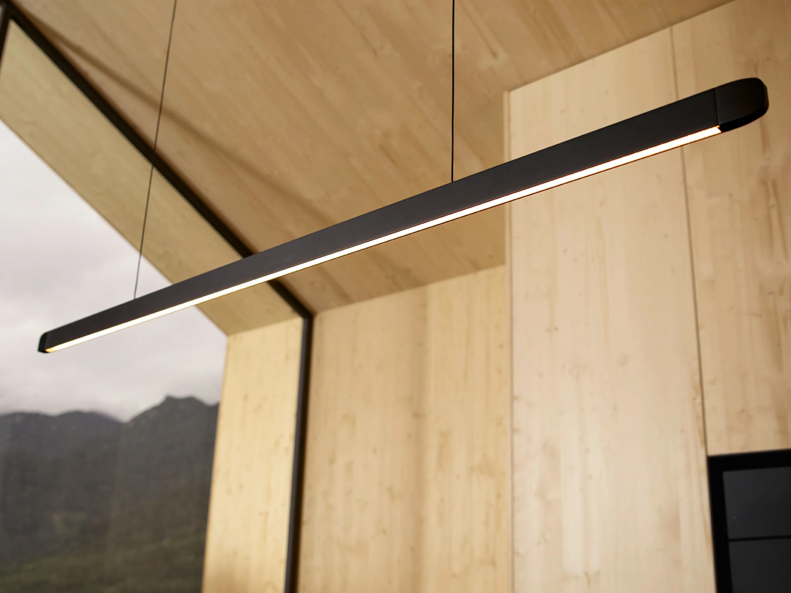 s97pqvdhnoq8ayy8kjz8 Detalj BORA STARS Horizon lampe – minimalistička linijska svetiljka sa mekim osvetljenjem i drvenim zidovima u pozadini.